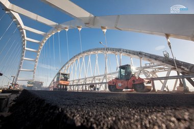 Строители асфальтируют полотно автодорожной арки Крымского моста
